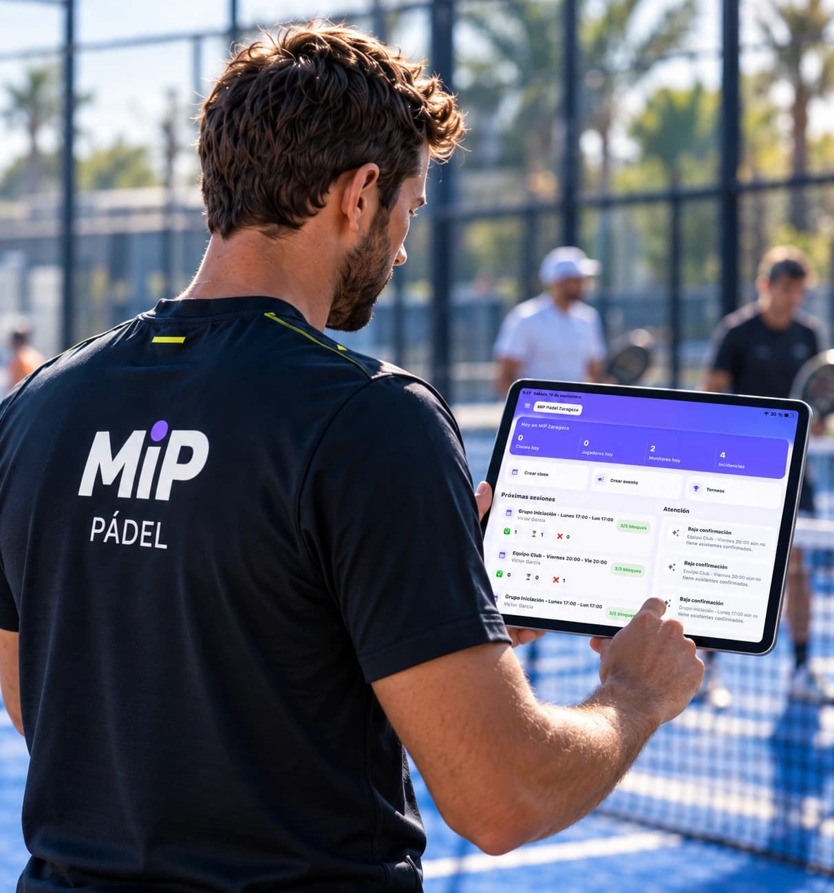 Monitor con camiseta MiP Pádel preparando una sesión en la tablet junto a la pista